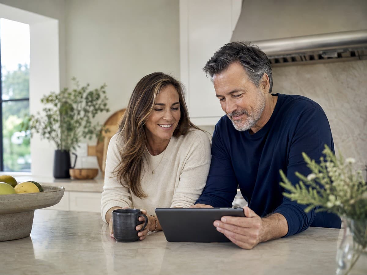 Couple reviewing information together on a tablet in their kitchen