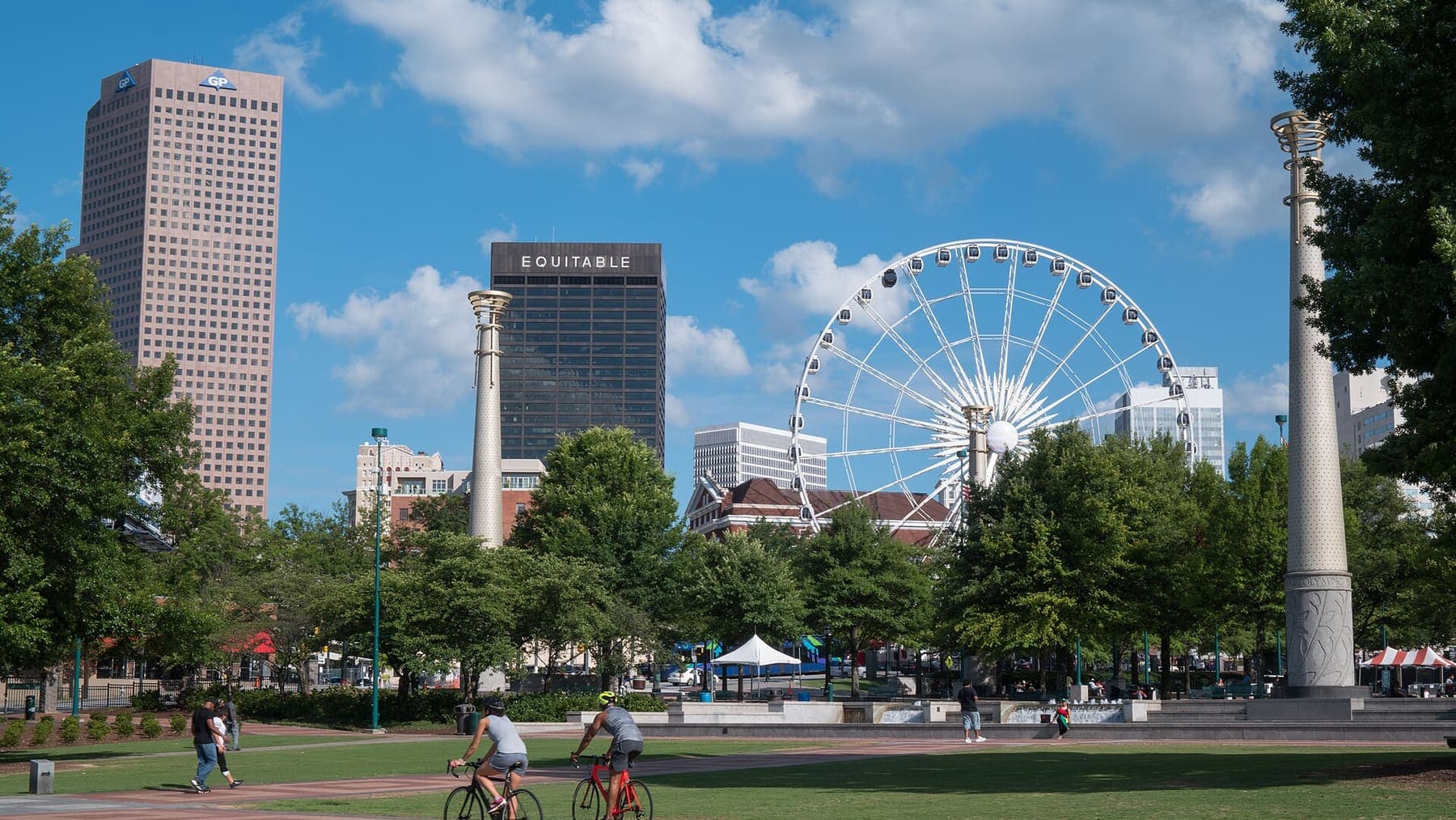 Georgia: Cyclists passing through Centennial Olympic Park with downtown Atlanta skyline in the background